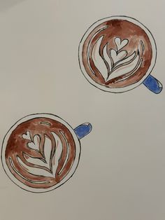 two cups of coffee with leaves drawn on the top one is brown and white, while the other is blue