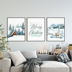 three christmas cards hanging on the wall above a couch in front of a christmas tree