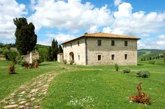 an old stone house sits in the middle of a green field