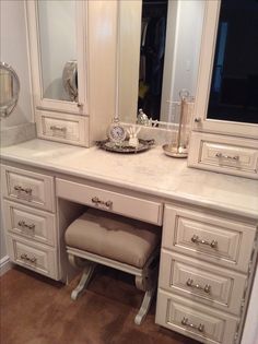 a white vanity with mirror and stool in a room