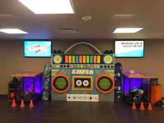 an arcade machine is set up in the middle of a room with orange cones and neon lights