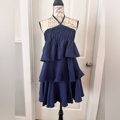 Navy Blue Tiered Halter Mini Sundress Smocked Back Three Tier Flowing Design Very Slimming And Flattering Adjustable Tie At Neck Fully Lined Side Zipper Closure Lightweight Satin Feel Material Brand New With Tags By Boutique Brand Fashion Ying Women’s Size Small 4-6 Pit To Pit 14-17” Total Length Pit To Bottom Hem 25” Bin W Tags- Gypsy, Boho, Chic, Wedding, Sunday, Weekend, Party, Fairy, Shower, Church, Beach, Holiday, Pin Up, Pinup, Sexy, Spring Break, Summer, Betty Paige, Romantic, Cocktail Su Blue Sundress With Ruffle Hem For Beach, Blue Ruffled Mini Sundress, Blue Mini Sundress With Ruffles, Casual Fitted Blue Tiered Dress, Blue Flowy Smocked Sundress, Blue Ruffled Sundress For Brunch, Blue Ruffle Sundress For A Day Out, Blue Sundress With Ruffle Hem For Vacation, Blue Smocked Mini Dress With Ruffles