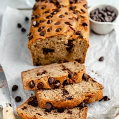 a loaf of banana bread with chocolate chips on top and two slices cut off the side