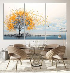 a dining room table with chairs and paintings on the wall