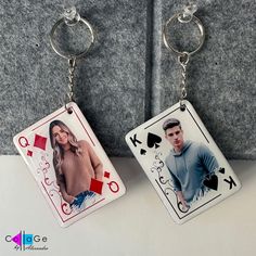 two key chains that have pictures of people playing cards on them, and one has a pair of scissors in it