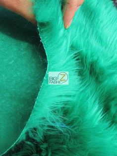 someone is cutting through the green fur on their coat to make it look like they are wearing