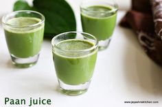 three glasses filled with green juice sitting on top of a table