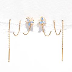 three pairs of ear clips with opal stones in gold tone setting on white background