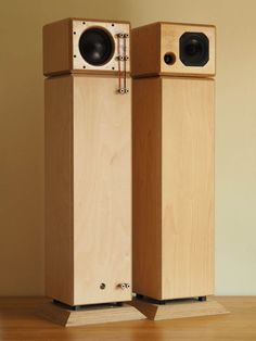 two wooden speakers sitting side by side on top of a hard wood flooring surface