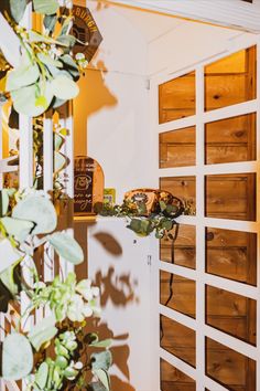 an open door leading into a room with wooden shutters and plants in the corner