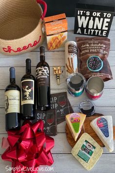 wine, cheese and crackers laid out on a table with a red bow around it