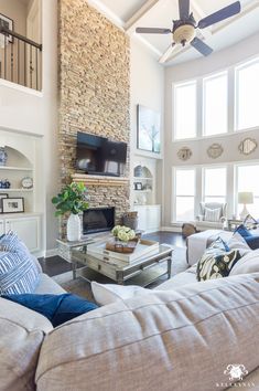 a living room filled with furniture and a flat screen tv mounted on the wall above a fireplace