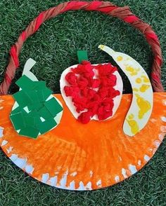 a paper plate with an apple on it and some other items in the shape of a pumpkin