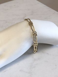 "14kt Yellow Gold Unisex Solid Open Link Bracelet 8\" in length. This unique and unusual Figaro pattern has a bright shiny plain polished finish, very flexible and comfortable to wear, a lobster claw clasp closure, 1/4\" wide all solid links and weighs 11.9 grams. This item would Retail for $1,789.00" Modern 14k Gold Silver Bracelets, Modern 14k Gold Bracelets In Silver Color, Modern 14k Gold Bracelets, Silver 14k Gold Oval Link Bracelets, Formal White Gold Bracelets With Figaro Chain, Formal White Gold Bracelet With Figaro Chain, Gold Hallmarked Sterling Silver Chain Bracelet, Elegant Sterling Silver Figaro Link Bracelet, Silver 14k Gold Bracelets With Polished Finish