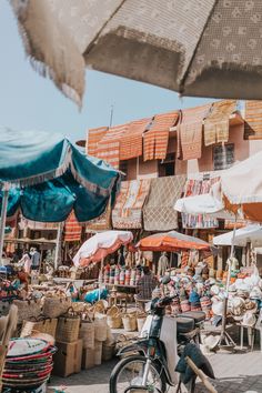 an outdoor market with lots of umbrellas and chairs