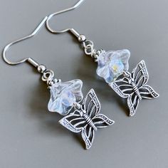 Butterfly Flower Earrings - Antiqued Silver Plated Filigree Butterflies dangle from Clear Crystal Czech Glass Flowers with Silver Plated Beads.  The flowers look like crystals and measure 10mm by 12mm. The earrings measure just under 2" from top of earwires to bottom. Surgical Steel Earwires Whimsical Butterfly Earrings With Ear Wire, Whimsical Butterfly Ear Wire Jewelry, Whimsical Butterfly Jewelry With Ear Wire, Red Flower Earrings, Silver Gold Earrings, Large Silver Hoop Earrings, Aqua Earrings, Fancy Earrings, Butterfly Gifts