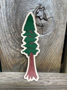 a sticker depicting a pine tree on a wooden surface