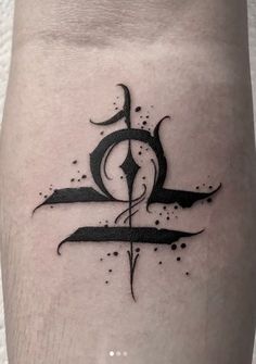 a black and white tattoo design on the leg, with an abstract symbol in the middle