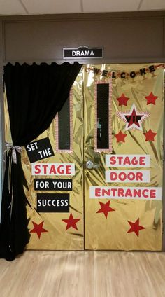 two stage doors decorated with gold and red stars for an entrance to a dance studio