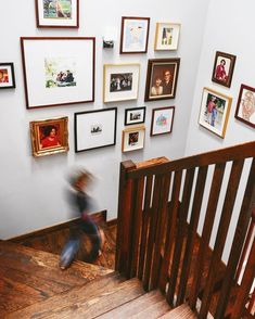 a person is walking up the stairs in front of some pictures