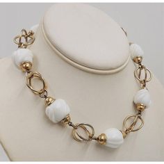 This is part of Chairish’s Costume Jewelry assortment.  1950s Modernist goldtone and white glass necklace with hook clasp. Marked "Napier." Measures: 5 1/2 inches long by 5 1/4 inches wide. Center; 11/16 inches long. Condition: Some minor wear to goldtone throughout, a few tiny dots on white beads. White Single Strand Glass Necklace, Vintage White Necklace, White Vintage Necklace For Formal Occasions, Vintage White Necklaces For Formal Occasions, Vintage White Metal Jewelry, Retro White Round Jewelry, Vintage White Single Strand Necklace, Vintage White Adjustable Necklace, White Adjustable Vintage Necklace