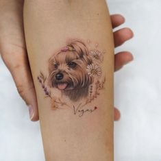 a woman's leg with a small dog tattoo on it