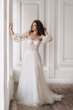 a woman in a white dress is posing for the camera