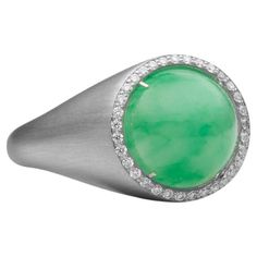 A BUNDA 'Corvus' Jade Ring, featuring a cabochon cut Jade of 4.75ct, enhanced with diamonds totalling 0.15ct, made in platinum. Australian Size M. Weight 15.69 grams.  Characteristics diamonds: 0.15cts F / VS Featuring a bold sculptural form this ring is true to the BUNDA signature 'Corvus' Collection of bold minimalist forms using impressive gemstones. Serial #SN:CORV1001.BB. Signed BUNDA. Modern Round White Gold Emerald Ring, Modern Polished Finish Gemstones, Fine Jewelry In Platinum With Cabochon, Fine Jewelry Platinum Cabochon, Modern Round Cabochon Emerald Ring, White Gold Cabochon Round Ring, Formal Round Emerald Ring With Single Cut Diamonds, Round Cabochon Diamond Ring, White Gold Round Cabochon Gemstones