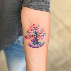 a woman with a colorful tree tattoo on her arm