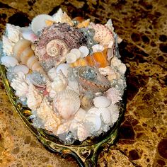 there are many different shells in the bowl on the counter top, and one is filled with them