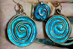 a pair of earrings with blue swirls on the front and back of each ear