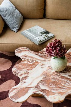 a living room with a couch, coffee table and flowers