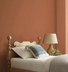 a bed in a bedroom with orange walls