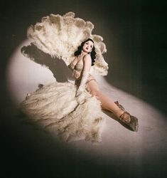 a woman laying on the ground in a white dress