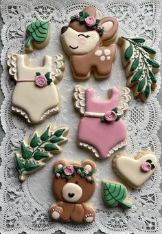 decorated cookies in the shape of teddy bears and baby ones on a lace doily