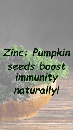 a wooden bowl filled with lots of green vegetables on top of a wooden table next to a sign that says, zinc pumpkin seeds booster immunity naturally