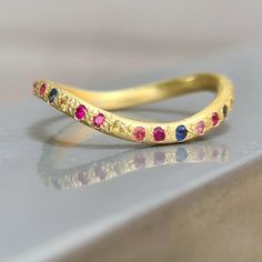 a close up of a gold ring with different colored stones on the inside of it