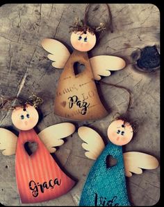 three wooden angel ornaments with names on them