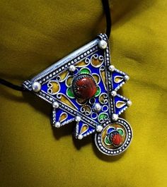 "A rare Berber talisman from the \"Ida Ou Samlal\" region of the anti Atlas. The talisman is handcrafted in sterling silver and enamelled in blue, green and yellow colors, and inlaid with real coral stones. **Height: 6 cm. **Width: 4.7 cm. **Leather cord: 54 cm. **Material: sterling silver 925, real coral. **Weight: 26 grams. **Origin: anti Atlas 1970s , Morocco. **Free shipping worldwide by DHL. I am always open to offers for one of my items, so please contact me if you would like to make an of Festival Medallion Amulet Jewelry, Festival Amulet Medallion Jewelry, Traditional Multicolor Collectible Necklaces, Collectible Amulet Jewelry For Festivals, Spiritual Ceremonial Filigree Jewelry, Traditional Handmade Necklaces For Collectors, Traditional Filigree Jewelry, Traditional Collectible Necklace For Festivals, Ceremonial Spiritual Filigree Jewelry