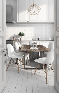 an open door leading to a kitchen with white chairs and a wooden table in the center