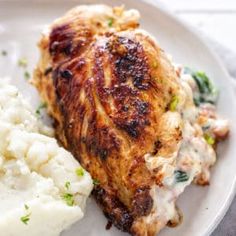 a white plate topped with chicken, mashed potatoes and broccoli