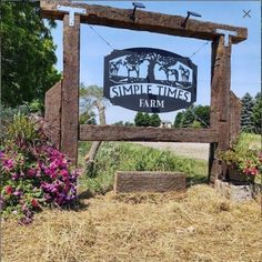 a sign for a farm with flowers in the foreground