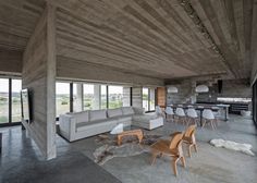 a living room filled with lots of furniture next to a kitchen and dining room table