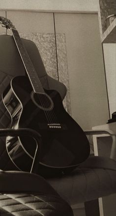 an acoustic guitar sitting on top of a chair