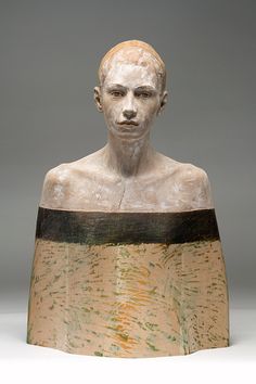 a sculpture of a man's head is shown in front of a gray background