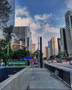 a city street with tall buildings and people walking on the sidewalk