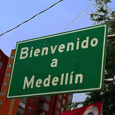 a green street sign hanging from the side of a pole