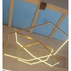 a suspended light fixture in the shape of an octagon with gold lines on it