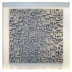 an abstract woven piece is displayed in a white frame