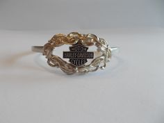 THIS IS A VERY PRETTY VINTAGE, HARLEY DAVIDSON CUFF  BRACELET. IT IS A GENUINE HARLEY ITEM. IT IS STERLING SILVER. MARKED STERLING FOR STERLING SILVER.   IT MEASURES  5 3/8" AROUND THE INSIDE, PLUS THE OPENING IS 1 1/2". SOMEWHAT ADJUSTABLE. THE FRONT MEASURES  7/8" HIGH.  IT IS IN NICE CONDITION. IT WEIGHS 16gm.  WORTHY OF BEING A GIFT.  THIS SHOP COMBINES SHIPPING. JUST PUT ALL ITEMS IN YOUR CART FIRST, THEN PAY FOR THEM. Vintage Harley Davidson, Bracelet Vintage, Vintage Harley, 925 Jewelry, Motorcycle Accessories, Sterling Silber, Sterling Silver Bracelets, Cuff Bracelet, Favorite Jewelry